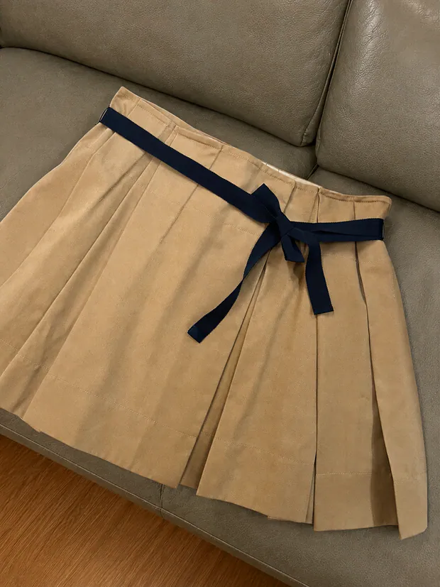 Wood-beige pleated skirt laid flat